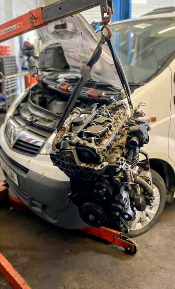 Van engine lifted out on the crane in the workshop